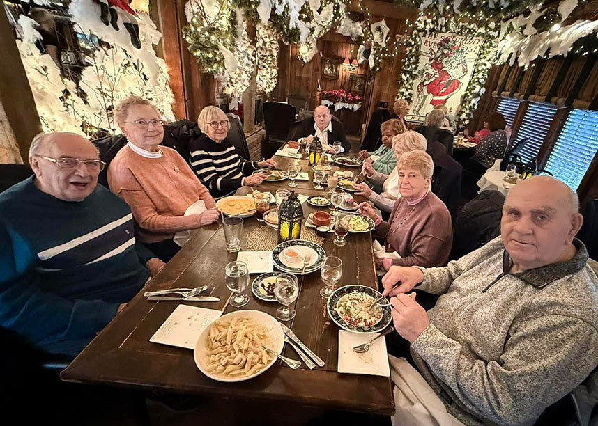 A group of senior residents enjoy an elegant dinner out.