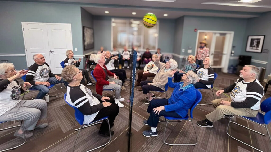 Residents at Vitalia Solon play a game of chair beachball volleyball in the fitness center.