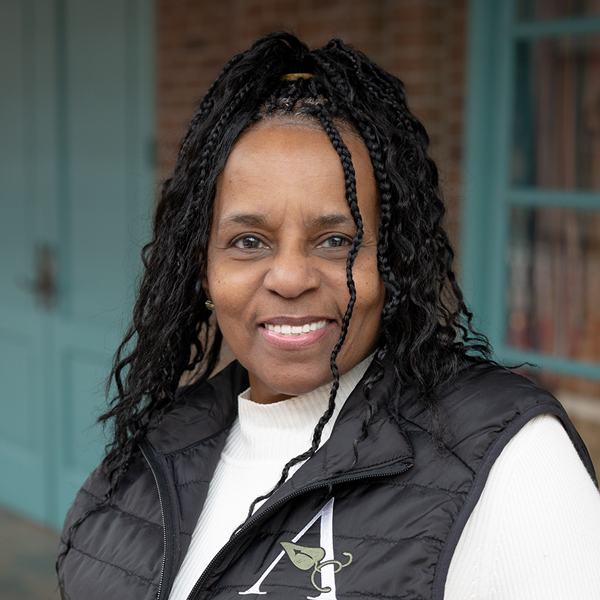 Annette Dendy, Resident Services Director at Vitalia Solon, smiling in a professional headshot, wearing a white top and black vest, standing outdoors with a softly blurred building background.