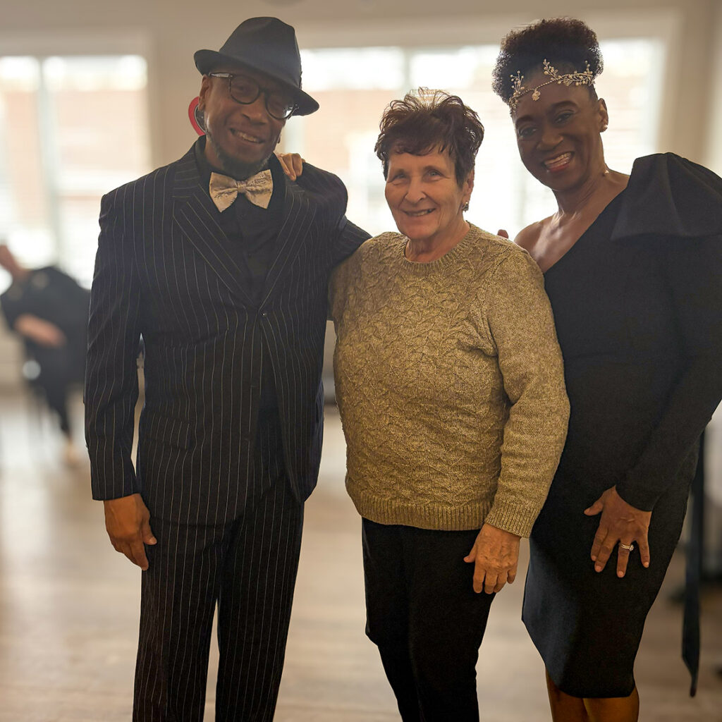 A senior woman and two loved ones dressed up for a party smile at Vitalia Solon.